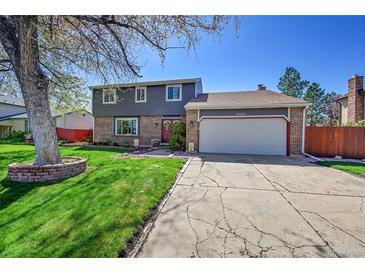 Charming two-story home with a well-manicured lawn, brick accents and a two car garage on a sunny day at 6527 S Yarrow Way, Littleton, CO 80123