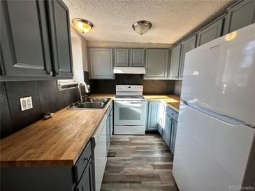 Updated kitchen with wood countertops, gray cabinets, and modern appliances at 8060 W 9 Th Ave # 115, Lakewood, CO 80214