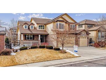 Charming two-story home with a manicured lawn and a covered front porch at 6043 S Paris St, Greenwood Village, CO 80111