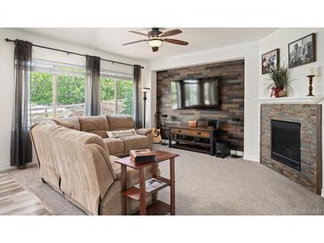 Inviting living room features a modern fireplace, wood accent wall, and comfortable seating area at 3834 Donnington Cir, Castle Rock, CO 80104