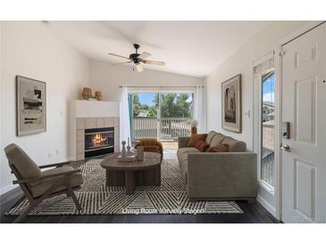 Bright living room with fireplace, balcony, and modern decor, creating a cozy atmosphere at 3825 Canyon Ranch Rd # 203, Highlands Ranch, CO 80126