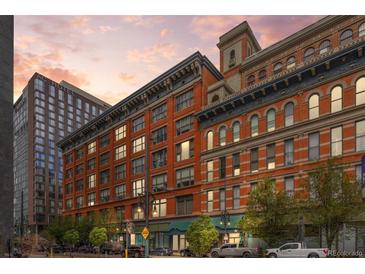 Exterior view of brick apartment building in city with street and sidewalk at dusk at 1555 California St # 419, Denver, CO 80202