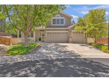 Charming home featuring a well-manicured lawn, mature trees, and a spacious three-car garage at 2938 S Zeno Way, Aurora, CO 80013