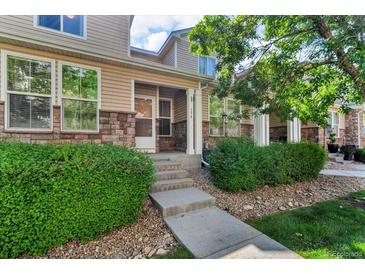 Charming townhome featuring stone accents, manicured landscaping, and a welcoming entrance at 9758 Laredo St # 35B, Commerce City, CO 80022