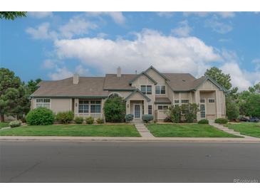 Charming two-story home with well-maintained landscaping and inviting curb appeal on a sunny day at 10087 E Hawaii Pl, Aurora, CO 80247