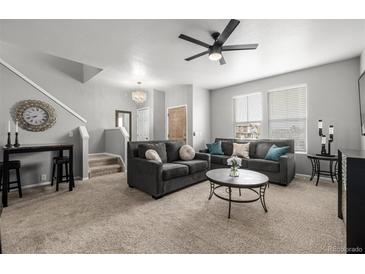 Bright living room featuring plush seating, a ceiling fan, and neutral decor, creating a cozy and inviting space at 9758 Laredo St # 37C, Commerce City, CO 80022