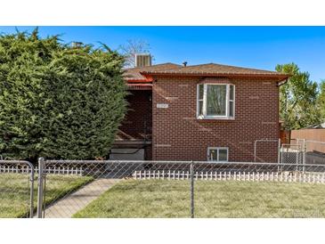 Charming brick home featuring a well-manicured lawn and mature landscaping at 2291 W 54Th Ave, Denver, CO 80221