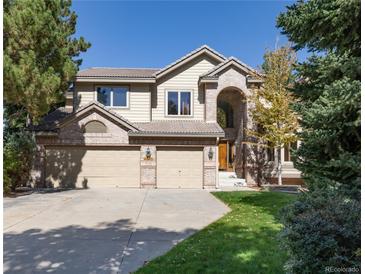 Stately two-story home boasts a three-car garage, brick accents, and mature landscaping in a suburban setting at 8812 Blue Mountain Pl, Highlands Ranch, CO 80126