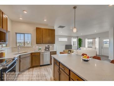Bright kitchen with stainless steel appliances, wood cabinets, and center island overlooking living area at 881 W 128Th Pl, Westminster, CO 80234