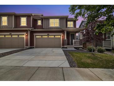 Charming home featuring a two-car garage and well-manicured lawn at twilight at 17848 Gallup St, Broomfield, CO 80023