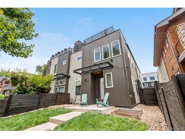 Modern two-story home featuring unique architectural design and a cozy front yard with landscaping and seating at 4557 Stuart St, Denver, CO 80212