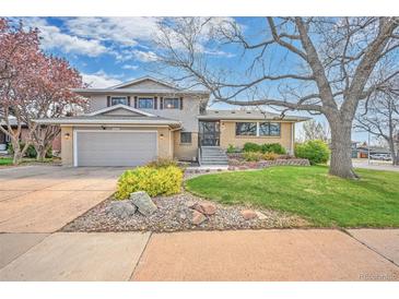 Charming two-story home with a well-manicured lawn, mature trees, and an attached two-car garage at 2194 S Braun Way, Lakewood, CO 80228