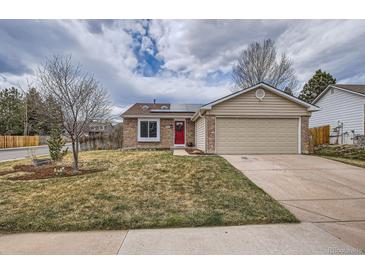 Charming single-story home featuring a brick facade, attached two-car garage, and a well-manicured front yard at 5587 S Simms Way, Littleton, CO 80127