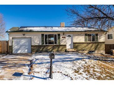 Ranch style home with attached garage and fenced yard at 1502 S Queen St, Denver, CO 80232