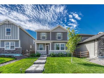 Charming two-story home with a well-manicured lawn and inviting walkway to the front door at 28428 E 8Th Pl, Watkins, CO 80137
