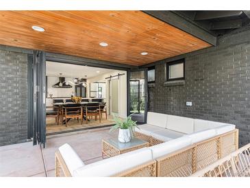 Inviting outdoor patio with comfortable seating area flows from dining and kitchen areas at 2140 Tabor Dr, Lakewood, CO 80215