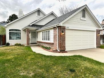 Charming one-story home featuring brick accents, a two-car garage, and a well-maintained front yard at 4493 Dunkirk Way, Denver, CO 80249