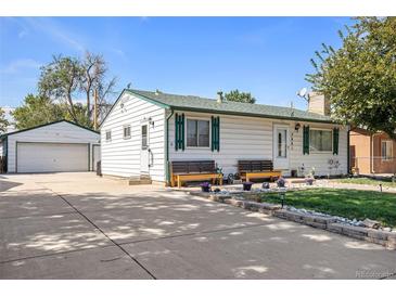 Charming home with a well-maintained front yard, benches, and a detached two car garage at 7891 Poplar St, Commerce City, CO 80022
