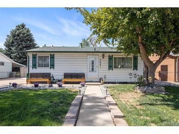 Charming single-story home with well-maintained lawn and inviting benches on front porch at 7891 Poplar St, Commerce City, CO 80022