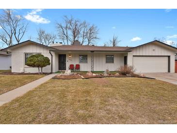 Charming single-story home featuring a well-maintained lawn, white siding and an attached two-car garage at 3175 Zinnia Ct, Golden, CO 80401