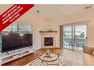 Bright living room with a fireplace and access to an outdoor patio, blending indoor and outdoor living at 14700 E 104Th Ave # 2802, Commerce City, CO 80022