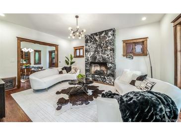 Bright living room featuring a modern fireplace, curved sofas, and contemporary lighting at 1440 Saint Paul St, Denver, CO 80206