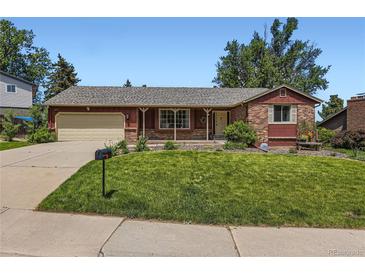 Charming single-story home featuring a well-manicured lawn and a classic brick and wood facade at 10247 W Arkansas Ave, Lakewood, CO 80232