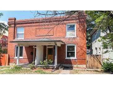 Charming brick two-story home featuring a covered porch, two front doors, and a well-maintained lawn at 2227 N Ogden St, Denver, CO 80205