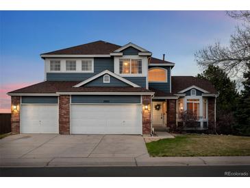 Charming two-story home featuring a three-car garage and manicured front lawn at 10103 Knoll Cir, Highlands Ranch, CO 80130