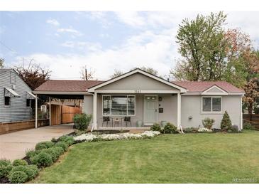 Charming home with a well-manicured front yard and covered front porch with seating area at 1561 W Beekman Pl, Denver, CO 80221