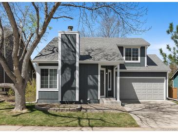 Charming two-story home with a gray exterior, manicured lawn, and attached two-car garage at 944 E Lily Ct, Highlands Ranch, CO 80126