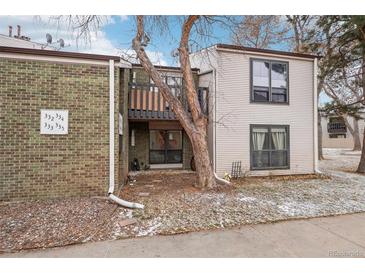 Inviting multi-level condo featuring brick and vinyl siding, complemented by mature trees and a cozy balcony at 3550 S Harlan St # 335, Denver, CO 80235