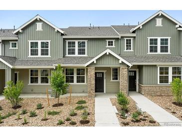 Charming townhome featuring a well-manicured front yard and welcoming covered entryway at 17117 W 91St Ln, Arvada, CO 80007