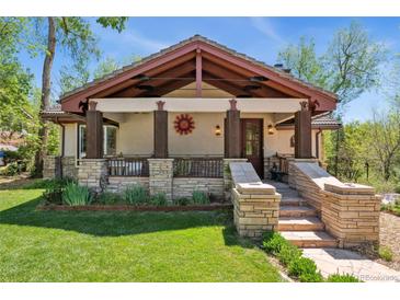 Charming home showcasing a welcoming front porch with stone accents and a well-manicured lawn at 740 Carr St, Lakewood, CO 80214