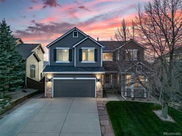 Inviting two-story home featuring a well-maintained lawn and an attached two-car garage at 9505 Painted Canyon Cir, Highlands Ranch, CO 80129