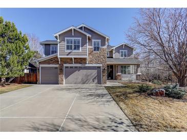 Charming two-story home with a three-car garage, stone accents, and a well-manicured front yard at 14032 Park Cove Dr, Broomfield, CO 80023