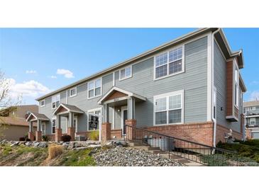 Charming townhouse with gray siding, brick accents, and a cozy covered entry at 8251 W 54Th Ave # 4, Arvada, CO 80002