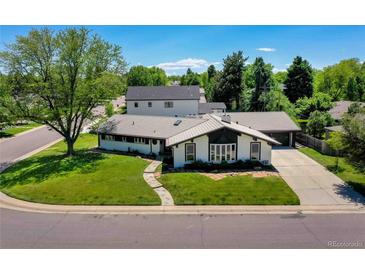 Stunning ranch-style home with a well-manicured lawn, mature trees, and a modern architectural design at 6220 E 5Th Ave, Denver, CO 80220