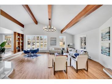Bright living room with vaulted ceilings, exposed beams, hardwood floors, and large windows allowing natural light to flood the room at 6220 E 5Th Ave, Denver, CO 80220