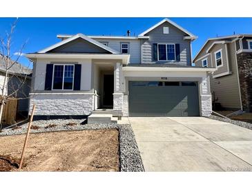 Charming two-story home featuring a modern gray color palette and well-manicured landscaping at 9728 Cathay St, Commerce City, CO 80022