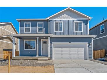Two-story blue home with white trim, attached garage and covered porch at 2212 Crosswind St, Fort Lupton, CO 80621