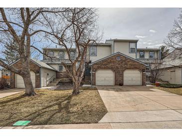 Charming townhouse with brick accents, attached two-car garage, and well-maintained front lawn at 8898 W Plymouth Ave, Littleton, CO 80128