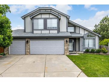 Charming two-story home featuring a three-car garage, stone accents, and manicured lawn at 8918 W 101St Ave, Broomfield, CO 80021