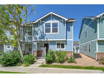 Charming two-story home with blue siding, well-maintained landscaping, and brick accents at 18947 E 57Th Pl, Denver, CO 80249