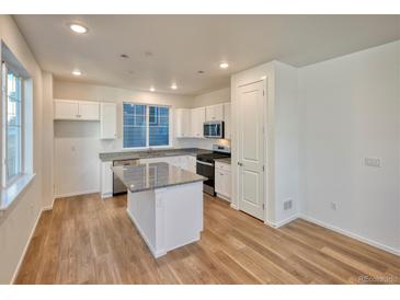 Bright kitchen features white cabinets, stainless appliances, and granite countertops at 23921 E 40Th Ave, Aurora, CO 80019