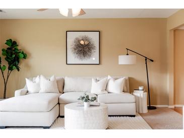 Bright living room featuring a comfortable, white sectional sofa and stylish decor at 654 S Xenon Ct, Lakewood, CO 80228