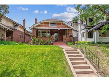 Charming brick home features a well-manicured lawn, landscaped front yard, and inviting front porch at 869 S Williams St, Denver, CO 80209