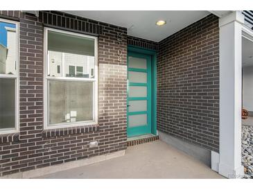 Attractive front entrance with modern-style turquoise door, brick facade and a concrete front step at 888 S Valentia St # 104, Denver, CO 80247