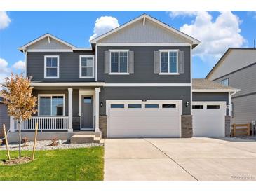 Beautiful two-story home with a three car garage, porch, and manicured front lawn at 1038 Scotts Peak Dr, Berthoud, CO 80513