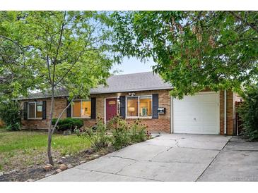 Charming brick home with a well-maintained front yard and a paved driveway leading to a two-car garage at 981 Ursula St, Aurora, CO 80011